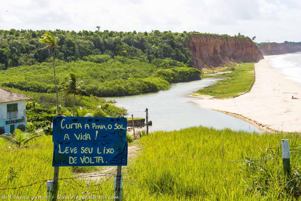 Imagem de uma placa dizendo pra curtir o sol e deixar a Praia Japara Grande limpa.